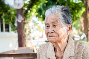 Enjoy Happy Asian old woman / grandmother smiling with her sitting alone with smooth expression /...
