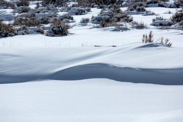 Snow covered desert landscape with puffy clouds and blue sky