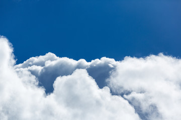 Blue sky covered in large puffy cumulonimbus cloud formations