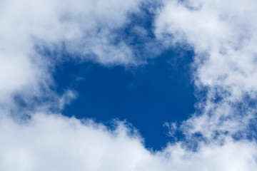 Blue sky covered in large puffy cumulonimbus cloud formations