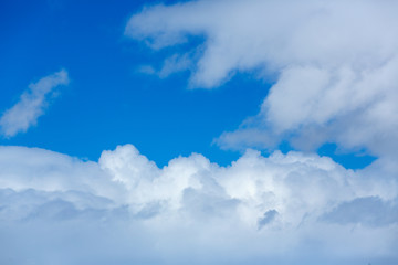 Blue sky covered in large puffy cumulonimbus cloud formations
