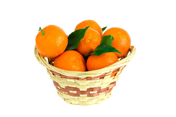 Bunch of fresh tangerines, clementines or mandarins in basket and leaves close up.