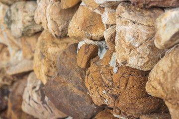 Closeup of a wall of natural stones on the beach.