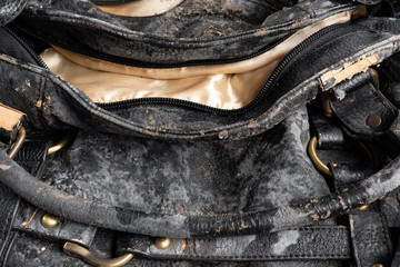 moldy leather bag on dark background close up