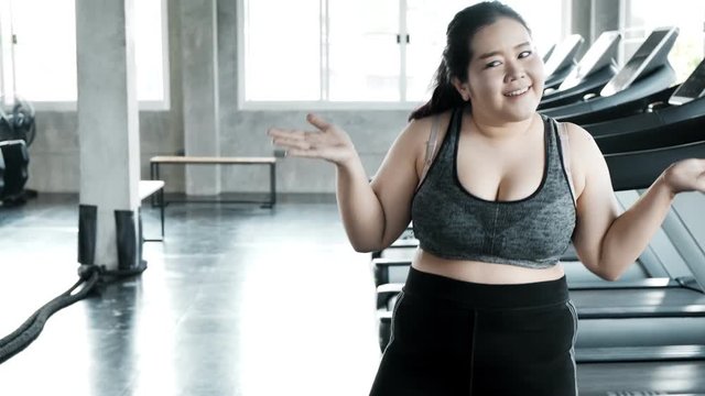 Young plus size start dancing in gym full of happiness. Happy plus size fitness lifestyle concept.