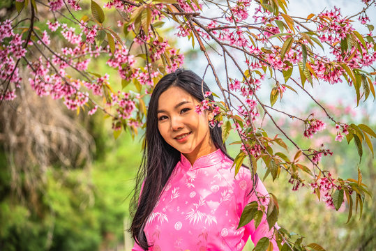 Beautiful young teenage girl wearing a pink posing in a park.