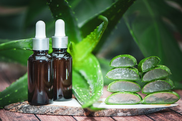 Aloe oil, juicy scarlet cut into pieces on a natural wooden background . Organic bio cosmetics