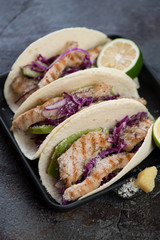 Tacos with red cabbage, grilled chicken, avocado, lime and cheese. Selective focus, studio shot