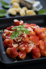 Closeup of italian gnocchi with strained tomatoes and grated parmesan, selective focus
