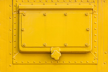 yellow painted metal plate texture with hatch and rivets