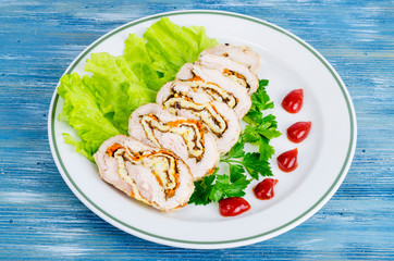 Plate of lettuce and slices of chicken roll.