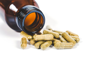 Alternative herb capsule spill out of bottle ,health concept.