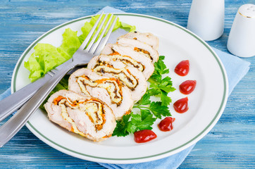 Plate of lettuce and slices of chicken roll.