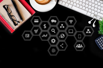 Office supplies with a laptop, smartphone, pen, tablet, notebook and coffee cup on a black background.