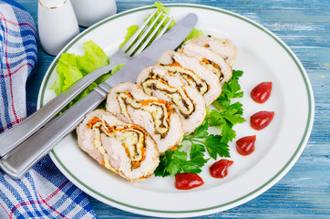 Plate of lettuce and slices of chicken roll.