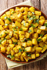 Delicious Indian potatoes Jeera Aloo with spices close-up on a plate. Vertical top view