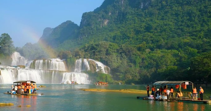 Cao Bang, Vietnam 10 2018: Tourist, traveller, tourism sightseeing waterfall and rainbow on wooden ferry. Ban Gioc waterfall or Detian waterfall is landmark in border Vietnam and Daxin County, China