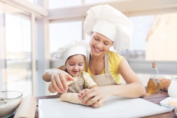 Portrait of adorable little girl and her mother baking together