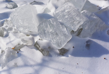 Fototapeta na wymiar pieces of transparent ice on white snow