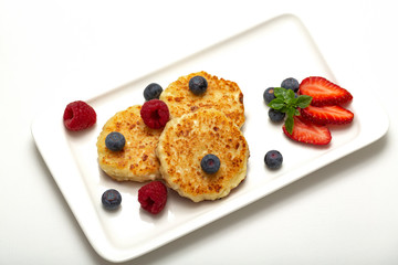 Cheesecakes from cottage cheese with raspberries, strawberries and blueberries. Healthy organic summer dessert cheesecake.