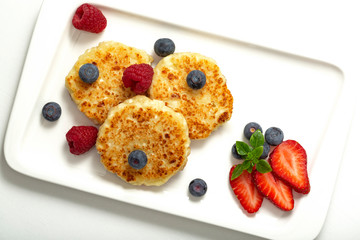 Cheesecakes from cottage cheese with raspberries, strawberries and blueberries. Healthy organic summer dessert cheesecake.