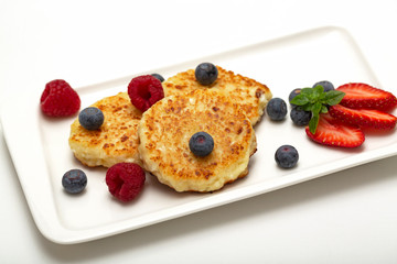 Cheesecakes from cottage cheese with raspberries, strawberries and blueberries. Healthy organic summer dessert cheesecake.