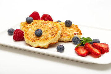 Cheesecakes from cottage cheese with raspberries, strawberries and blueberries. Healthy organic summer dessert cheesecake.