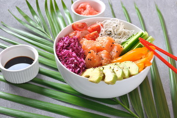 Fresh seafood recipe. Organic food. Fresh salmon poke bowl with crystal noodles, fresh red cabbage, avocado, cherry tomatoes. Food concept poke bowl 