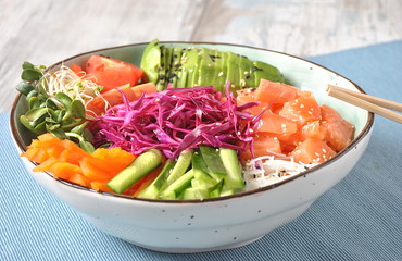 Fresh seafood recipe. Organic food. Fresh salmon poke bowl with crystal noodles, fresh red cabbage, avocado, cherry tomatoes. Food concept poke bowl 