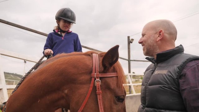 Girl giving high five to her horse riding coach