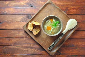 Chicken soup with noodles and vegetables in bowl on wooden background homemade healthy meal