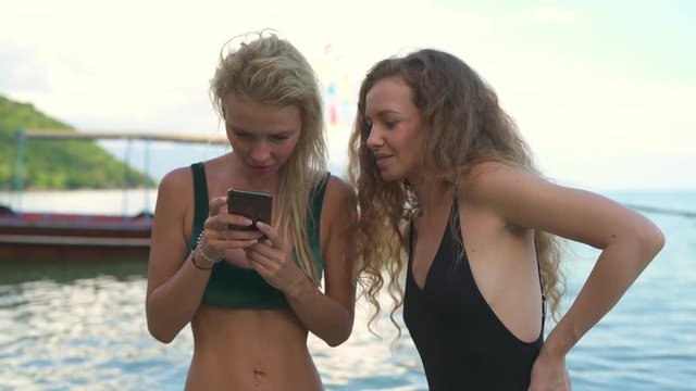 Girls looking at pictures on iPhone on Koh Tea beach