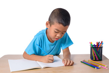 Cute cheerful child drawing using color pencil while sitting at table isolated on white background