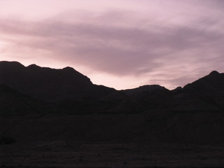 Desierto de Dahab, montañas de Egipto en la noche fotos contra del sol y nubes moradas violetas