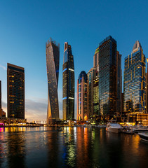 Fototapeta na wymiar Dubai marina modern skyscrapers and luxury yachts at blue hour
