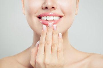 Natural beauty concept. Closeup female smile with natural pink lips and french manicure hand