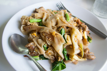 Stir fry noodles  in white bowl.