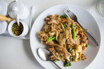 Stir fry noodles  in white bowl.