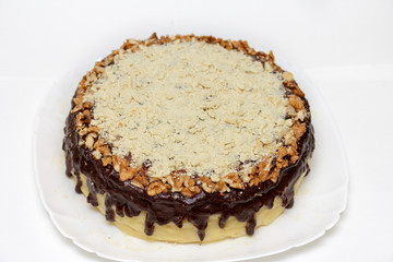 Delicious round cake with custard, walnuts and chocolate icing