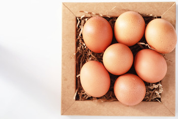 Chicken brown eggs on a white table