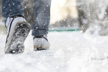 A man walks through the city on snowy winter day.