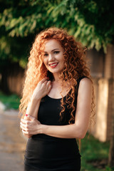 Portrait of beautiful redhead woman in green grass