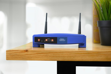 closeup of a wireless router and a man using smartphone on living room at home ofiice