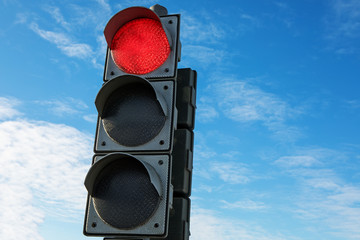 Traffic red stoplight light on a background of blue sky