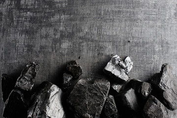 Natural coal on a black background isolated closeup. Extraction of natural mineral resources.