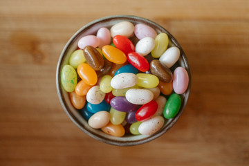Jelly candy beans on a bowl. Close up view of candy beans with selective focus on wooden background.  