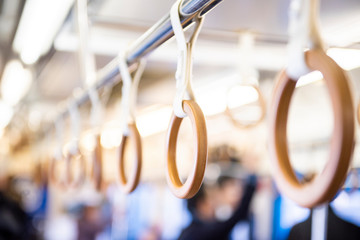 Yellow wooden  hand grip straps inside subway train