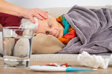 Obraz na płótnie Canvas Sick elderly woman on the couch