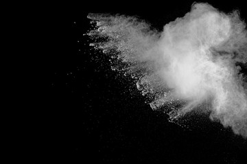 White powder explosion isolated on black background. White dust particles splash.Color Holi Festival.