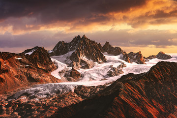 Alpine mountain landscape with glacier and peaks covered by snow